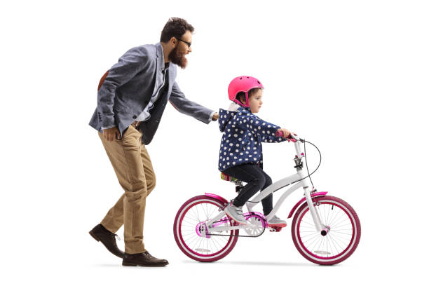 istock Father teaching daughter to ride a bicycle 1205964884