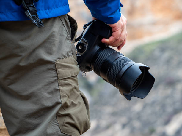 istock Hand of a man holding a camera in the mountain 1205964912
