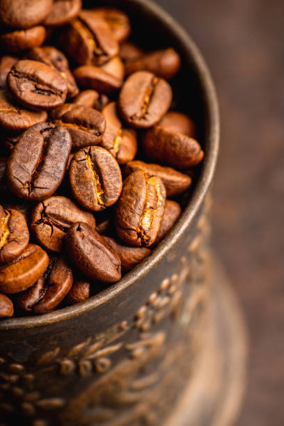 istock Coffee beans on the rustic wooden background 1205967522