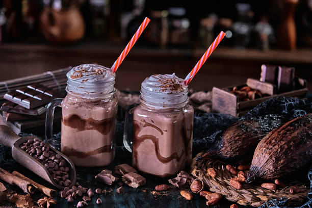 low key chocolate smoothies milkshakes in mason jars on a table in a rustic kitchen - milk old fashioned retro revival still life imagens e fotografias de stock