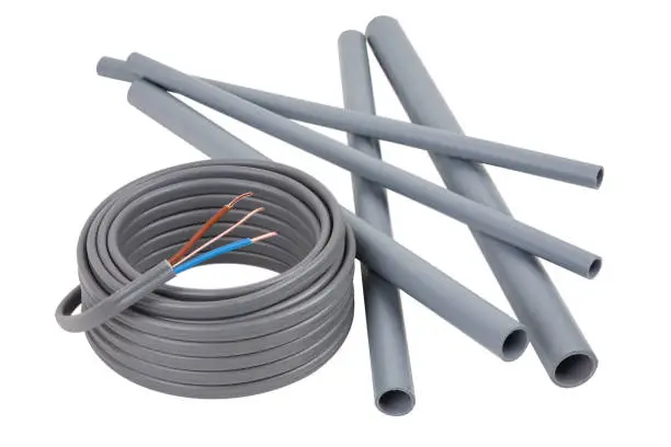 Photo of Electrical cables and pipes on a set of building plans, isolated on a white background