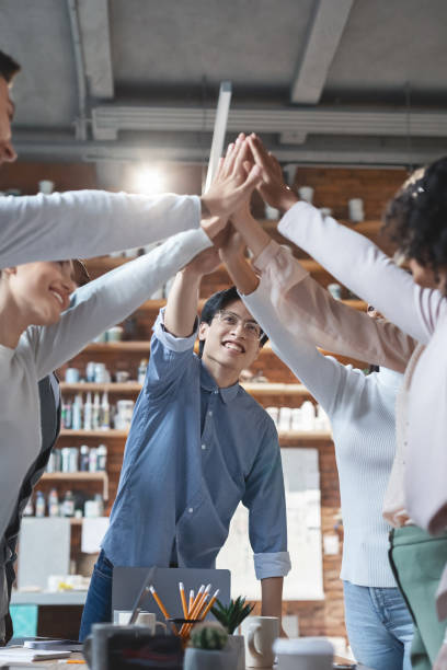 istock Inspired manager giving high five to his international young team 1205972326