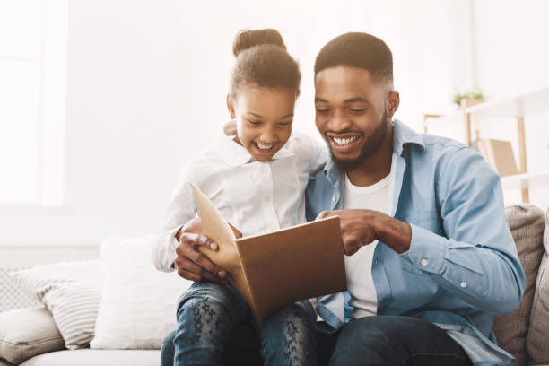 istock Happy evening. Afro dad reading fairy tale to his daughter 1205972708