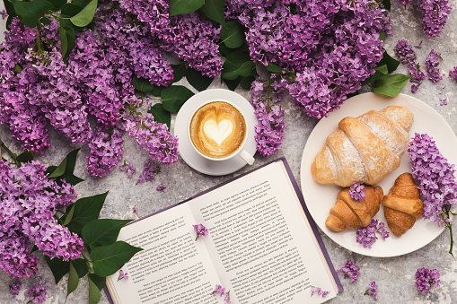 Spring flat lay with lilac, top view on flowers and book