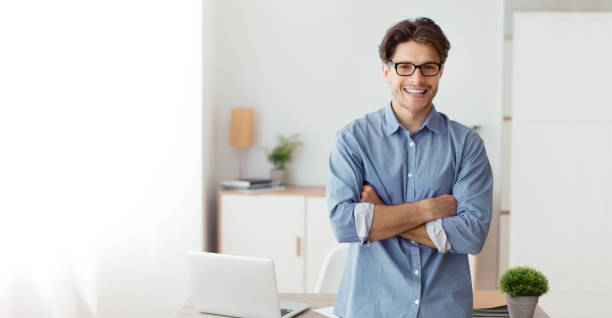 istock Confident Freelancer Guy Crossing Hands Standing In Home Office, Panorama 1205975092