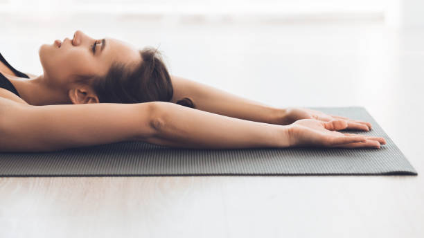 istock Woman stretching lying on the floor in modern studio 1205975422