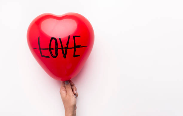 istock Crossed out love text on heart balloon on white background 1205976280