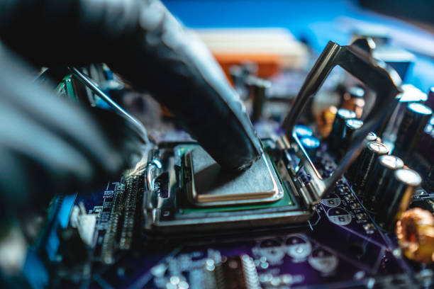 istock Engineer repairman holding hands CPU to insert into the socket of the motherboard. Technology hardware in the neon light 1205977432