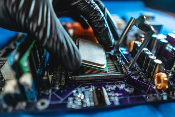 istock Engineer repairman holding hands CPU to insert into the socket of the motherboard. Technology hardware in the neon light 1205977446