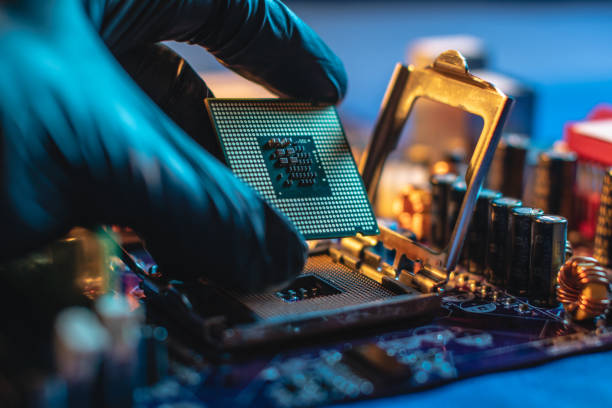 istock Engineer repairman holding hands CPU to insert into the socket of the motherboard. Technology hardware in the neon light 1205977547