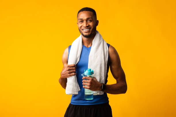 istock Healthy afro guy holding bottle of water 1205978254