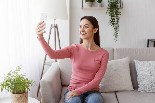 istock Attractive millennial woman making happy selfie on cellphone 1205979478