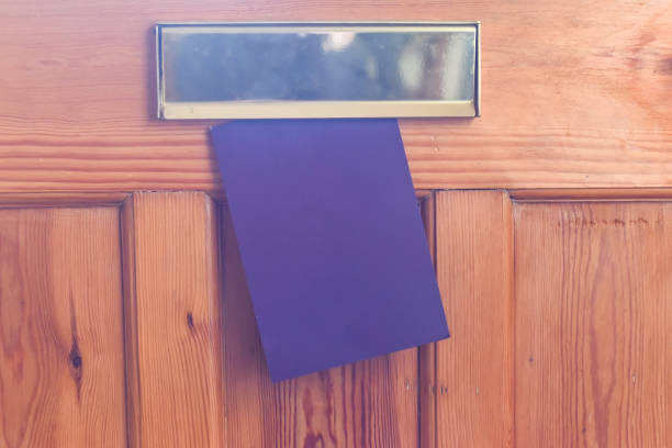 Blank leaflet or flyer being posted through a letter box unwanted junk mail