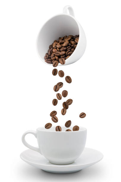 istock Roasted coffee beans falling into coffee cup on saucer with white background,fresh and bright wallpaper concept. 1205982471