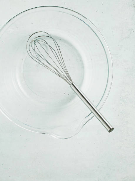 istock kitchen whisk in an empty glass bowl on the table. food background 1205982564