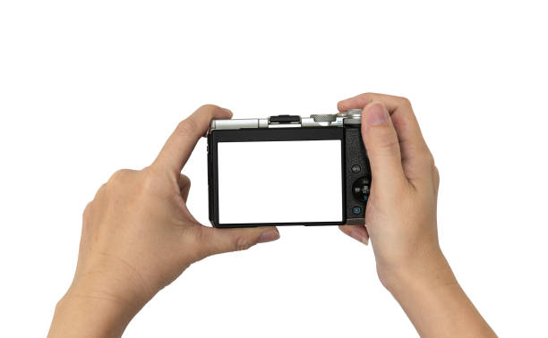 istock Hand holding DSLR digital camera.Isolated on white background with clipping Path. 1205982645