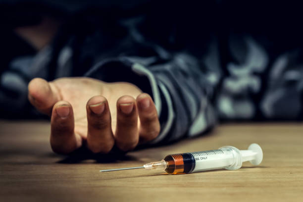 Addict man dead after inject drug overdose with syringe injection heroin to hand.Social disaster and epidemic of narcotic addiction concept. Addict man dead after inject drug overdose with syringe injection heroin to hand.Social disaster and epidemic of narcotic addiction concept. morphine drug stock pictures, royalty-free photos & images