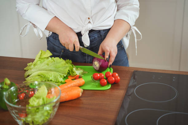 istock Close up of female hands that cutting onion 1205983323