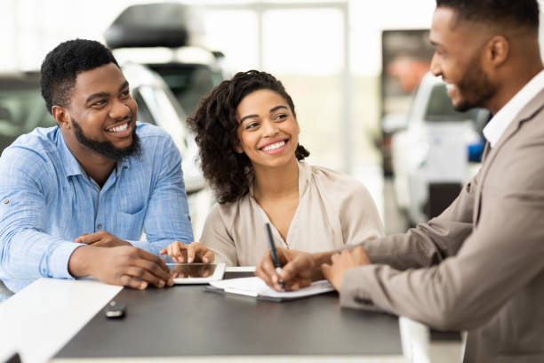 para zakup samochodu podpisywanie dokumentów ze sprzedawcą w biurze dealerskim - car african descent shopping car dealership zdjęcia i obrazy z banku zdjęć