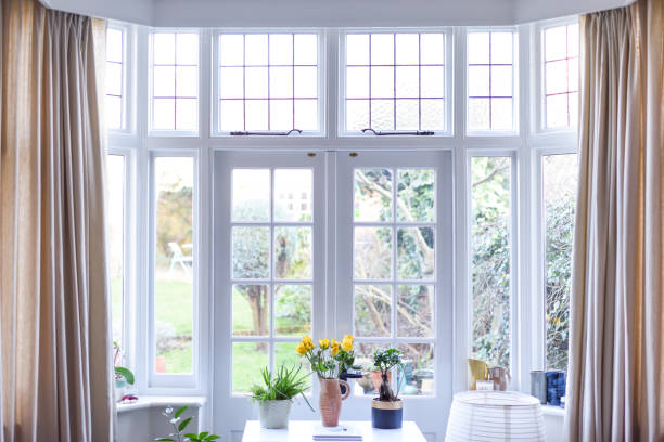 モダンな家庭で、フレンチドアと明るいニュートラルな色を持つスタイリッシュな客室のインテリア - ドア 写真 ストックフォトと画像
