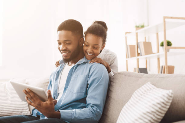 istock Positive african father and daughter using digital tablet 1205988684