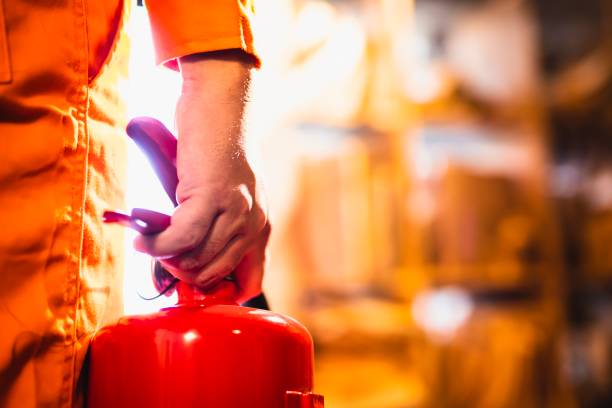istock mage of hand holding fire extinguisher 1205989018