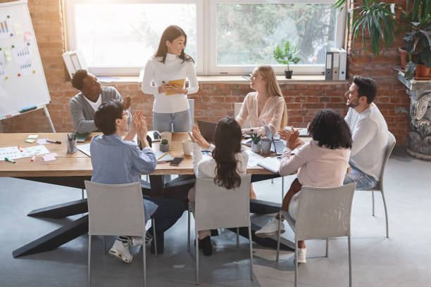 istock Asian lady making report in front of business team 1205989249