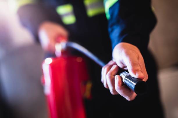 homem conceito usando extintor de incêndio combate a incêndio de perto - extinguishing - fotografias e filmes do acervo