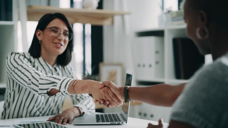 4k video footage of two young business colleagues shaking hands during an interview in the office