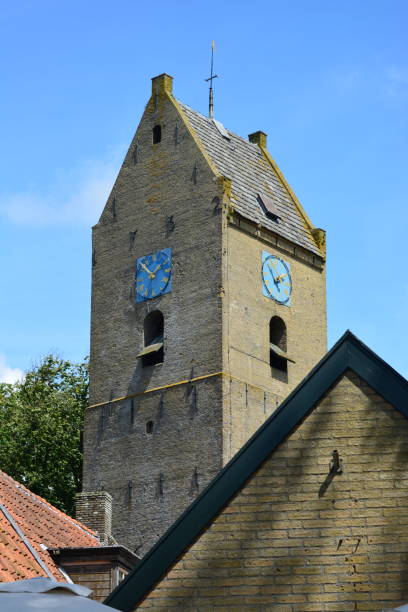 historical old church tower on ameland, nes, a vibrant tourist village - nes stock-fotos und bilder