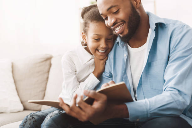 istock Loving daddy reading book to his happy daughter 1205991967