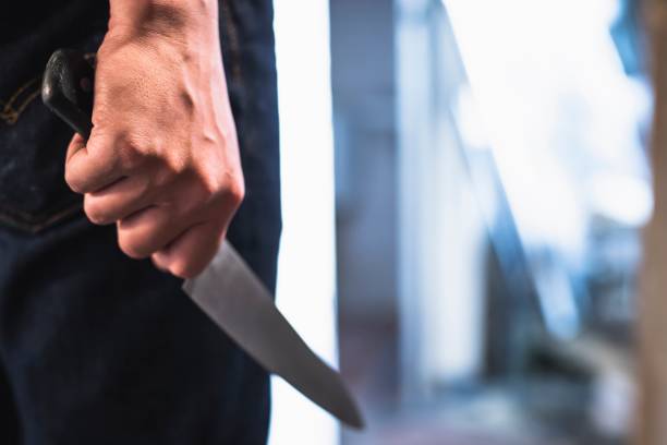 immagine di un ladro mani tenendo un coltello nell'ombra. - coltello da cucina foto e immagini stock