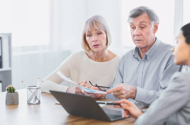 istock Focused mature couple talking to financial advisor at home 1205993461