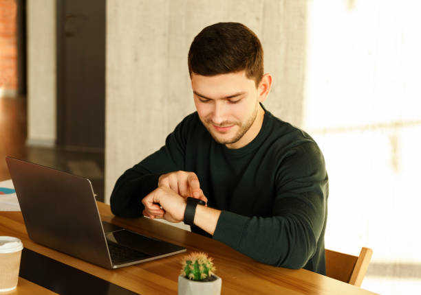 istock Office Worker At Laptop Checking Time Sitting In Office 1205994444