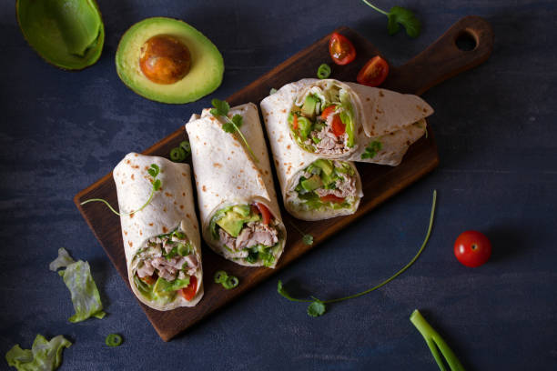 istock Turkey wraps with avocado, tomatoes and iceberg lettuce on chopping board 1205995992