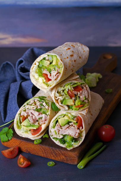 istock Turkey wraps with avocado, tomatoes and iceberg lettuce on chopping board 1205996107