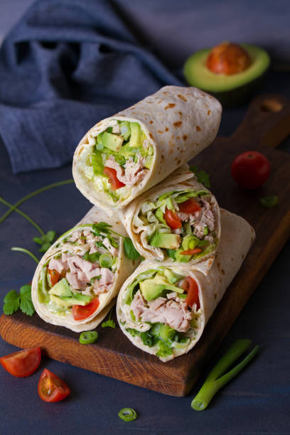 istock Turkey wraps with avocado, tomatoes and iceberg lettuce on chopping board 1205996405