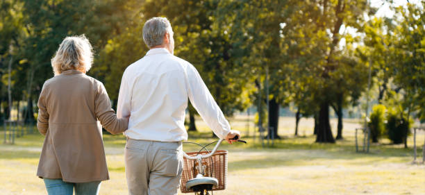 Caucasian elderly couples come to relax in the park during the summer. Of long holidays and Picnic. Tourism activities Of retire. Friendship, love and care your health. Health insurance concept stock photo