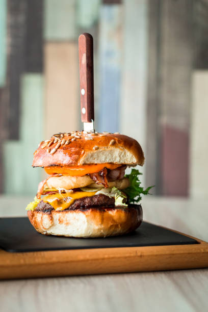 Fresh flame grilled bacon cheeseburger on wooden board