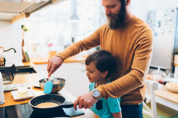 istock Single father with son cooking pancakes at home 1205999513