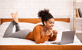 Happy Black Woman Using Laptop Making Video Call At Home
