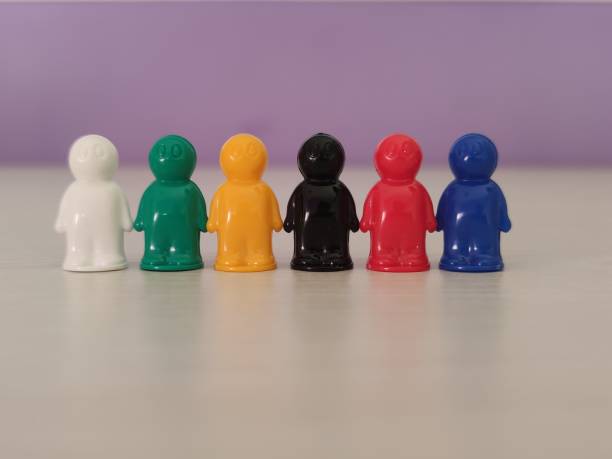 Conception  - partnership, cooperation, game figures or pawns in a business situation. Colored chips of tabletop game in the little men form