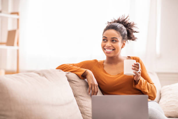 istock Lady With Laptop Having Coffee Sitting On Sofa At Home 1206001361