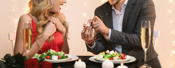 istock Man making marriage proposal to surprised girlfriend on dinner in restaurant 1206001500