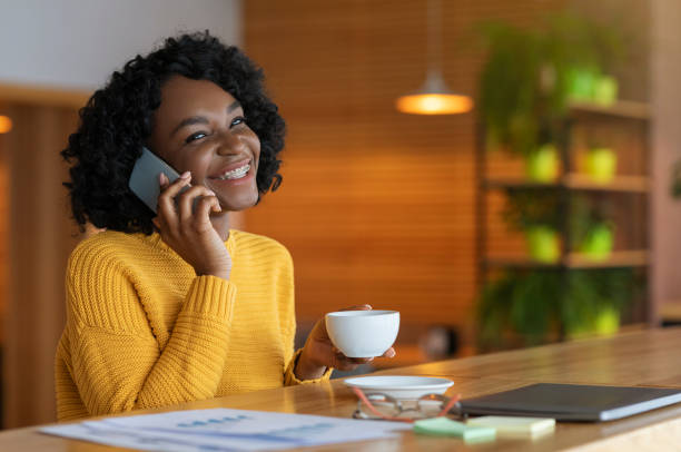 istock Happy young black businesswoman drinking coffe at cafe, having conversation 1206003989