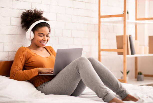 istock Happy Black Girl Using Laptop Studying Lying In Bedroom 1206004557