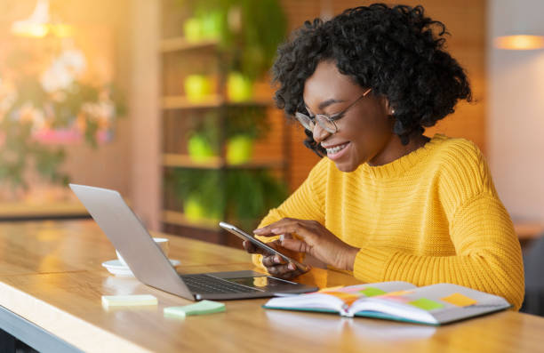 istock Happy black girl working online and using mobile phone 1206004989