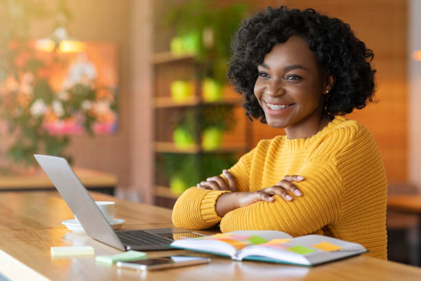 istock Satisfied afro girl using laptop at cafe, working online 1206006626
