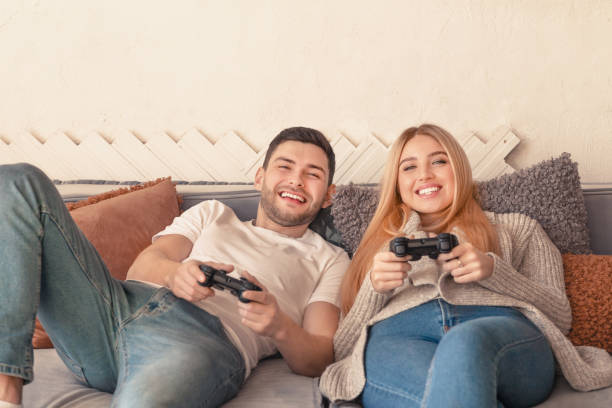 istock Happy couple holding joysticks and playing video game 1206007539