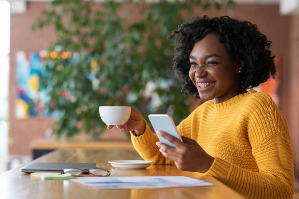 istock Emotional afro girl drinking coffee and using smartphone 1206008057